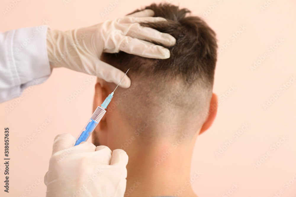 Man with hair loss problem receiving injection on color background Man with hair loss problem receiving injection on color background