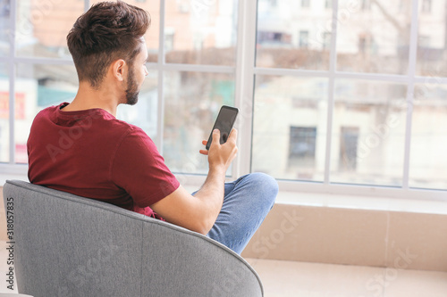 Young man with mobile phone at home Free Download Young man with mobile phone at home - GFXLoad