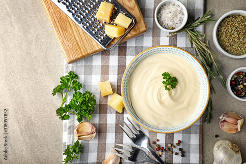 Photos Bowl with tasty sauce and ingredients on grey background