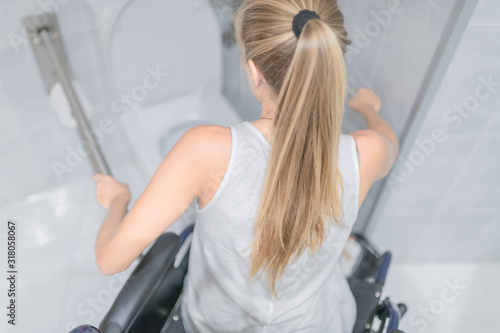 woman moving from wheelchair to bathroom