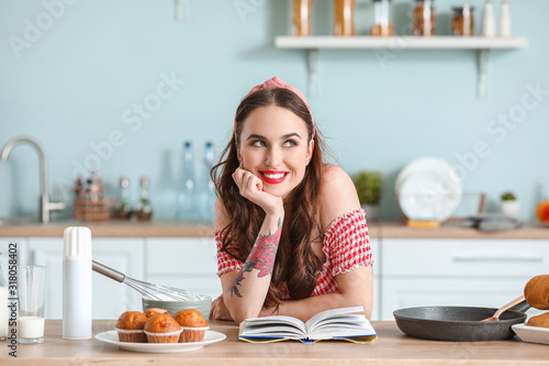 Beautiful young housewife cooking in kitchen