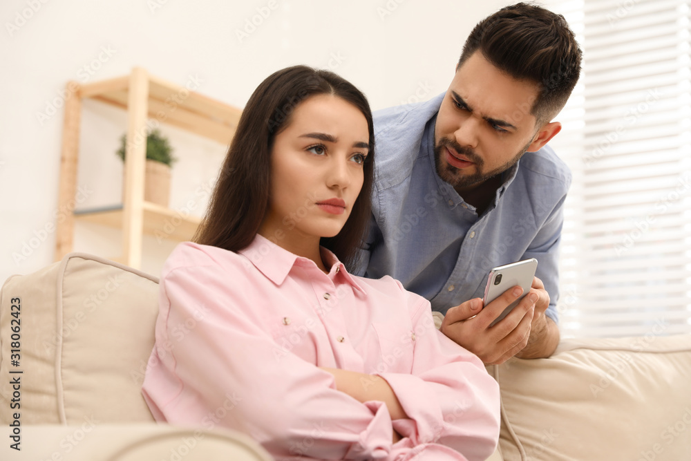 Young couple arguing about smartphone at home. Problems in relationship Young couple arguing about smartphone at home. Problems in relationship