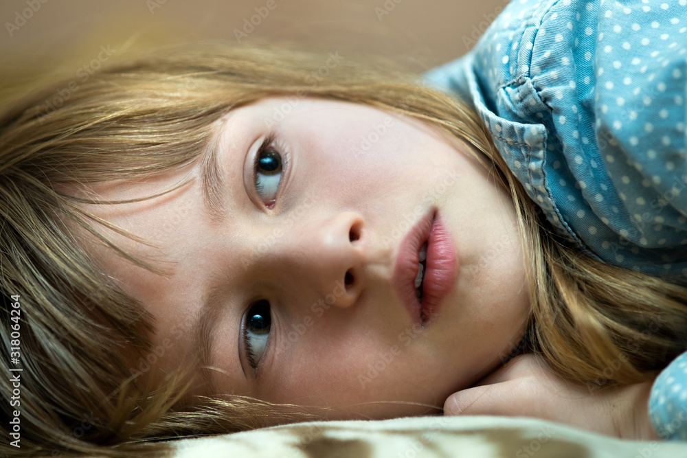 Portrait of a pretty child girl laying down at home. Portrait of a pretty child girl laying down at home.