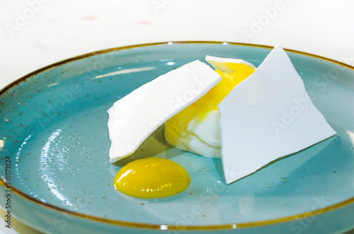 Φωτογραφία Italian dessert coconut pannacotta with yellow citrus, pineapple jelly, jam, filling, slices of fruit, meringues on blue plate in restaurant