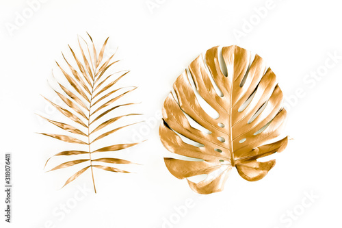 Gold tropical palm leaves Monstera on white background. Flat lay  top view minimal concept.
