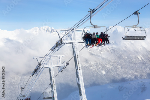 Whistler, British Columbia, Canada. People going up the mountain on a Chairlift during a vibrant and sunny winter day.