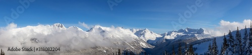 Whistler  British Columbia  Canada. Beautiful View of the Canadian Snow Covered Landscape with Blackcomb Mountain in Background during a cloudy and sunny winter day.