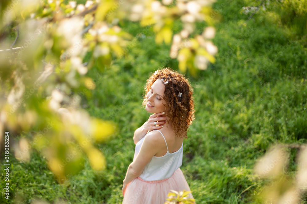 Young attractive girl walks in spring green park enjoying flowering nature. Healthy smiling girl spinning on the spring lawn. Allergy without Young attractive girl walks in spring green park enjoying flowering nature. Healthy smiling girl spinning on the spring lawn. Allergy without