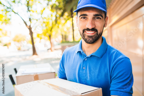 Bilde på lerret Delivery man carrying package outdoors.