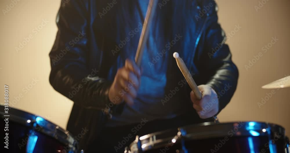 A professional drummer is playing rock music with band. Experienced musician is beginning the performance in club - music concept 4k footage