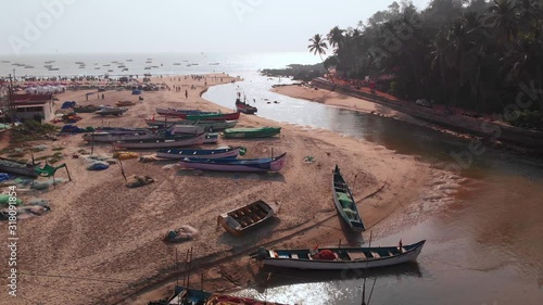 Aerial view of a small Indian river with wooden fishing boats on Baga Beach, Goa, India