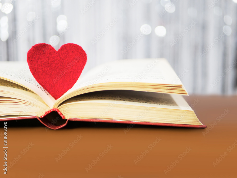 Red heart with old book concept. Greeting card for Valentine's day. Textile red heart for Valentines holiday. Romantic background and wallpaper Red heart with old book concept. Greeting card for Valentine's day. Textile red heart for Valentines holiday. Romantic background and wallpaper