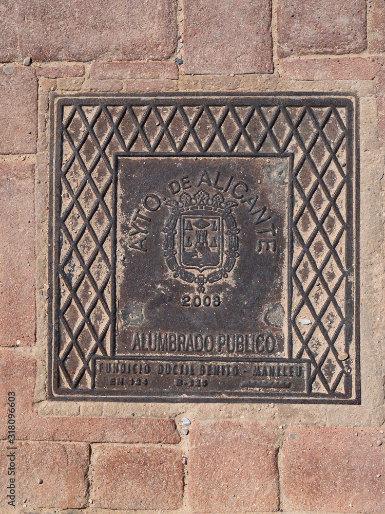 Manhole cover on pavement with patterns