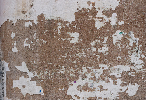 old white and brown wall with peeling paint and chipped - rough texture for a background