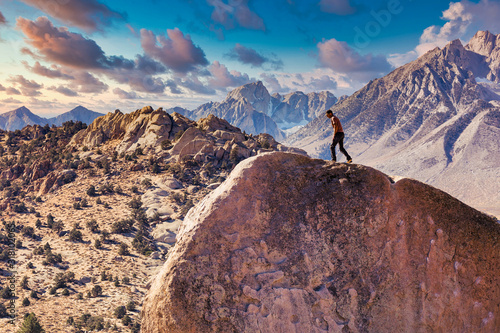 Fotografie Man rock climbs on huge granite boulder in the Buttermilk area of Bishop, Califo