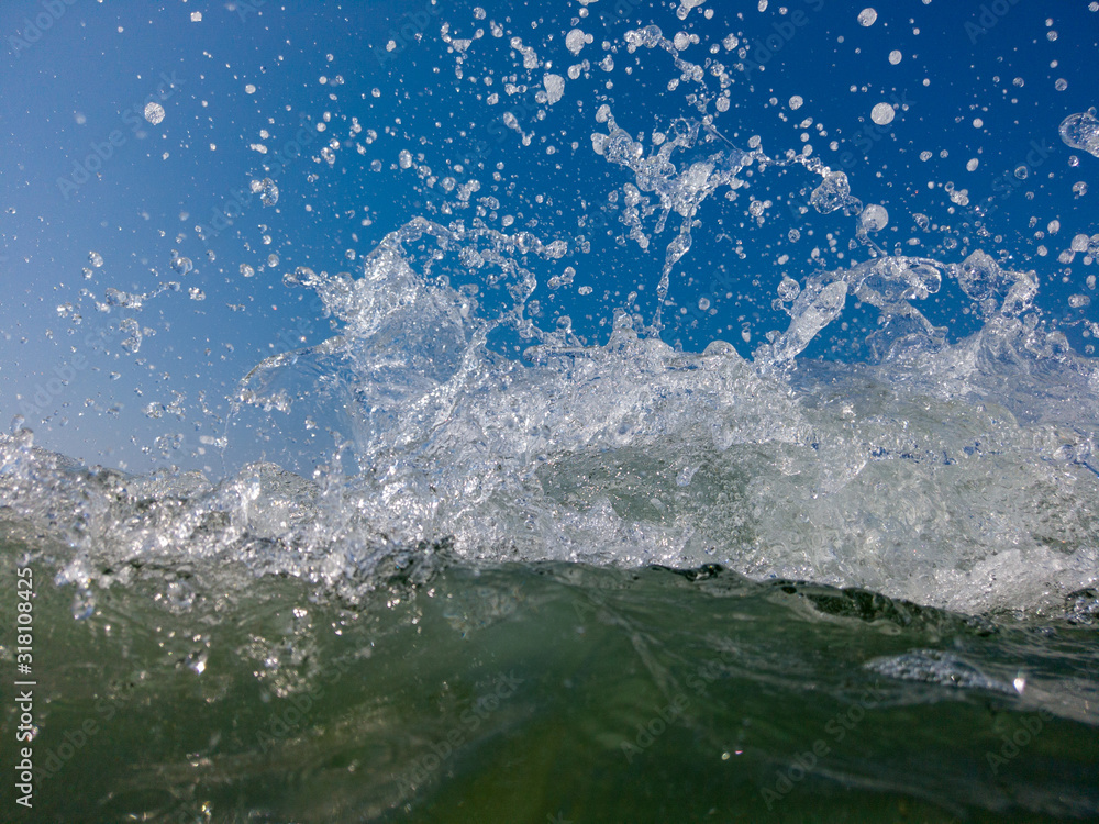 The low tide from the sandy beach. Ocean waves are splashing on the shore. The low tide from the sandy beach. Ocean waves are splashing on the shore.
