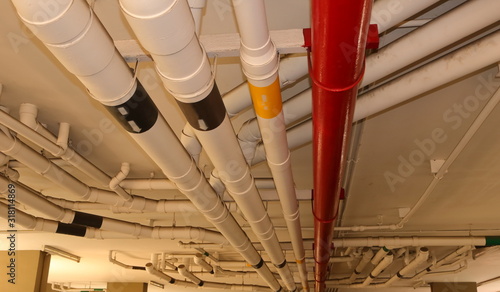 Water distribution system pipes installed by hanging from ceiling, selective focus, the red pipe will be used during fire fighting 