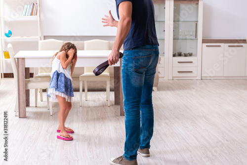 Angry father punishing his daughter