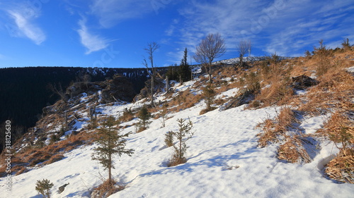 Snowy rocks in winter mountainous landscape on a sunny windy cloudless day