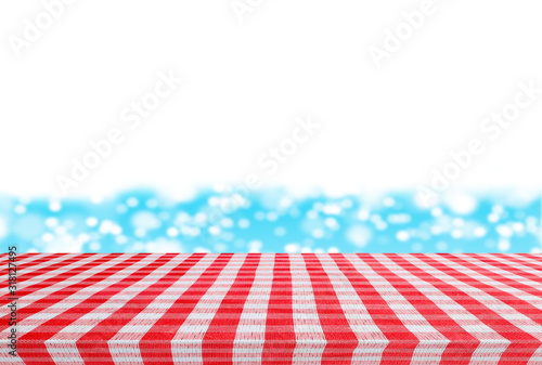 Red checkered tablecloth texture top on blur sparkling sea water and summer sky background