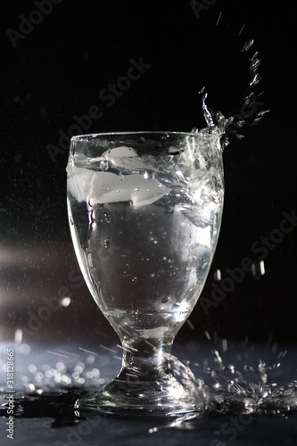Refreshing drink - glass of icy cold water, isolated on black