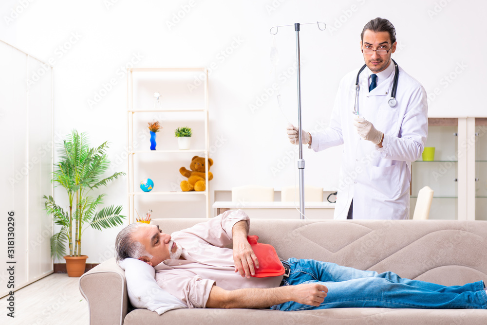 Obraz premium Young male doctor visiting old patient at home