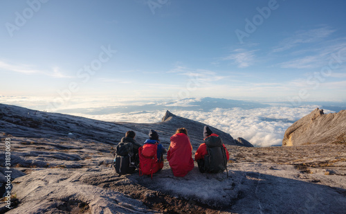 Принти на полотні Group of travelers with backpack sitting on Kota Kinabalu's summit, Malaysia in the morning