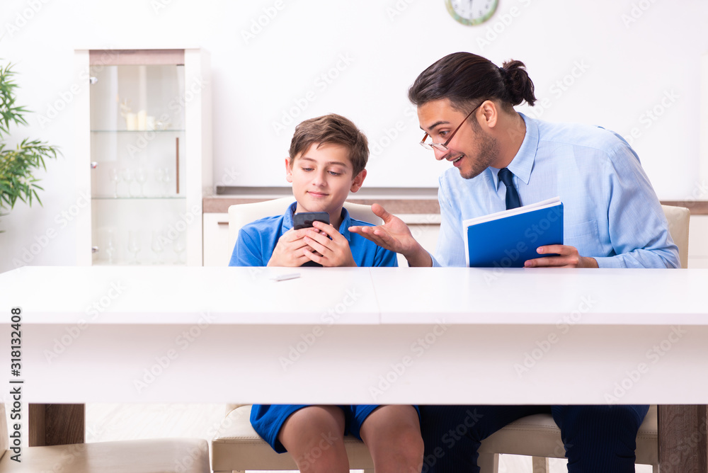 Busy father helping his son to prepare for exam Busy father helping his son to prepare for exam