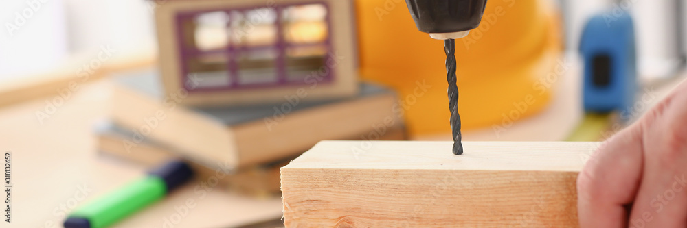 Arms of worker using electric drill closeup. Manual job DIY inspiration improvement job fix shop yellow helmet joinery startup idea industrial education profession career concept Arms of worker using electric drill closeup. Manual job DIY inspiration improvement job fix shop yellow helmet joinery startup idea industrial education profession career concept