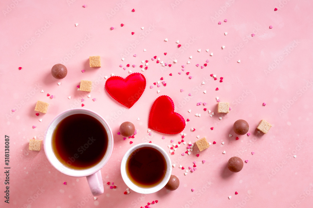 Love drinks. Coffee tea cups for two, sweets candy chocolate on pink hearts background. Valentines day 14 february minimal concept Love drinks. Coffee tea cups for two, sweets candy chocolate on pink hearts background. Valentines day 14 february minimal concept