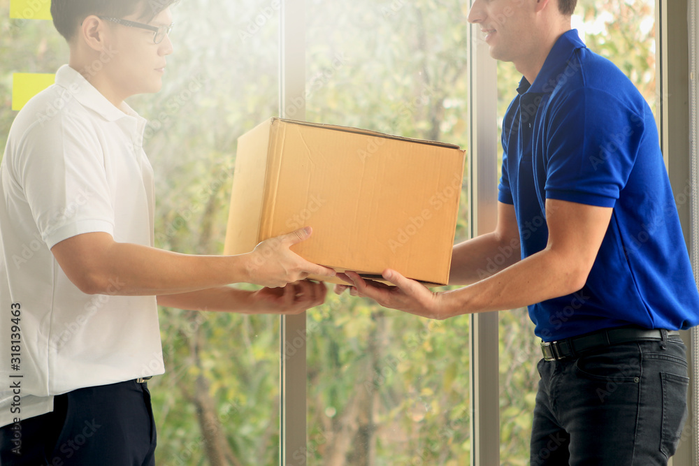 Delivery man holding parcel box and handing over cardboard box to customer, tracking, shipping and courier delivery services express concept. Delivery man holding parcel box and handing over cardboard box to customer, tracking, shipping and courier delivery services express concept.