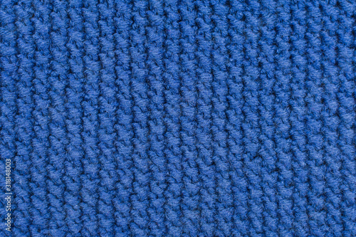Knitted fabrics. Background of a knitted fabrics. Blue cloth with diagonal stripes knitted by hand. Knitted pattern as background.