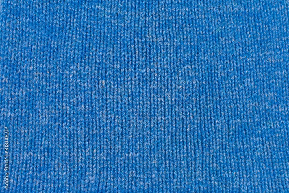 Needlework, hobbies, knitting. Background textile fabric with a knitted texture wool blue. Blue knitted fabric texture. Hand knitting. Needlework, hobbies, knitting. Background textile fabric with a knitted texture wool blue. Blue knitted fabric texture. Hand knitting.
