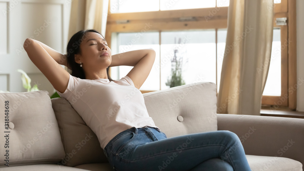 Calm Vietnamese girl relax at home couch breathing air Calm Vietnamese girl relax at home couch breathing air
