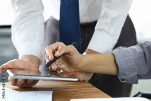 Close-up of manger and customer speaking about condition of agreement. Client signing electronic documents on modern tablet. Business and company concept