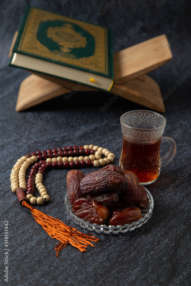 food Ramadan Sweets mixed of dried fruits and nuts Glass Tea with  rosary and the Quran on the table,