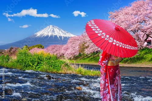 Photos Asian woman wearing japanese traditional kimono and looking at cherry blossoms with fuji mountains in Shizuoka, Japan