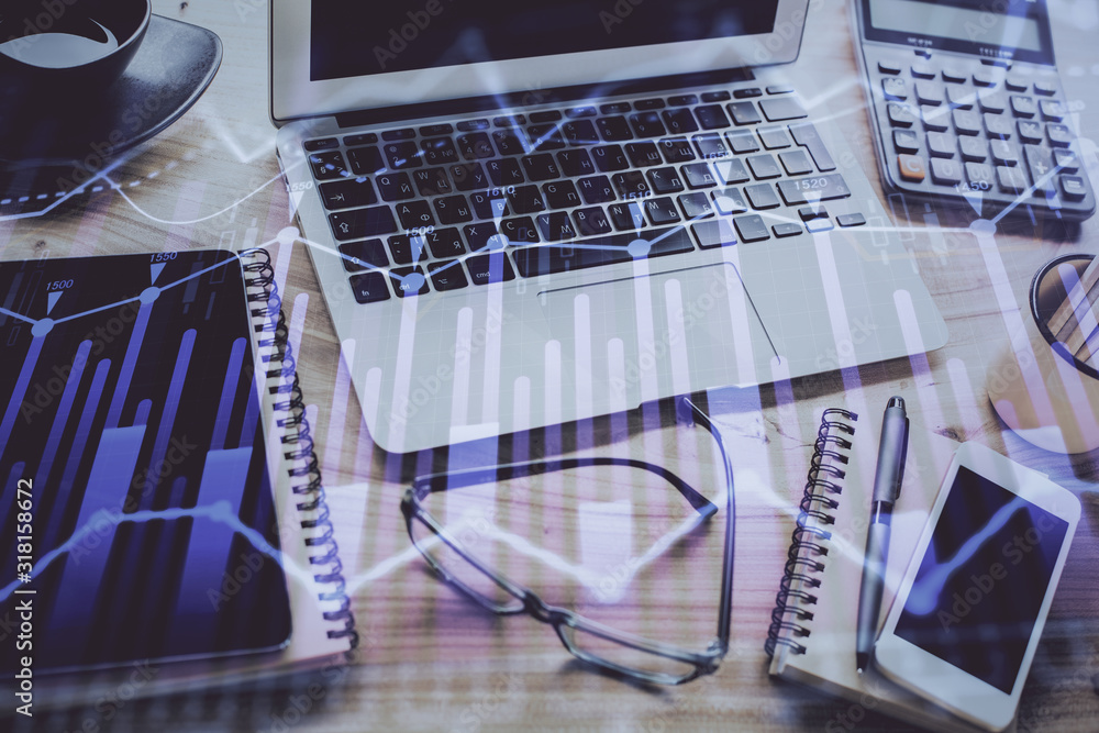 Stock market chart hologram drawn on personal computer background. Multi exposure. Concept of investment. Stock market chart hologram drawn on personal computer background. Multi exposure. Concept of investment.