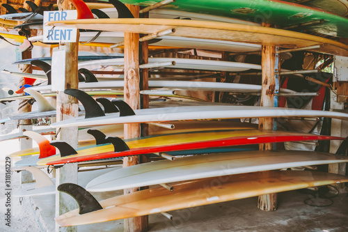 Colorful surf boards in shop for rent on the beach. water sports equipment. vintage color tone effect.