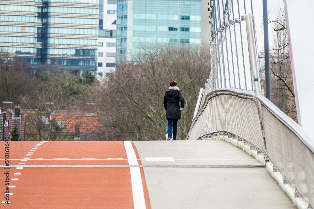 Φωτογραφία Wide angle shot of a person walking on a bridge in front of skyscrapers