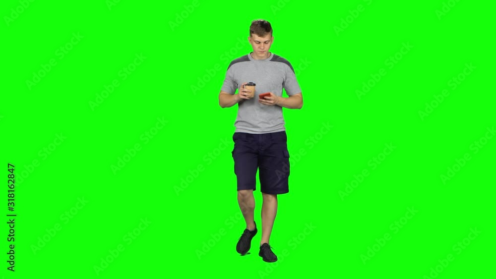 Young man walking talking on the phone and drinking coffee. Chroma Key Young man walking talking on the phone and drinking coffee. Chroma Key