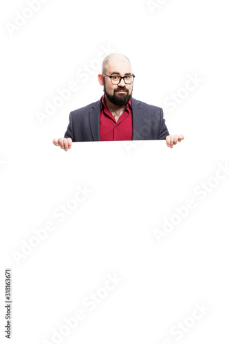 A bald man in glasses with a beard holds an empty banner. Dressed in a formal suit. Isolated on a white background. Vertical.