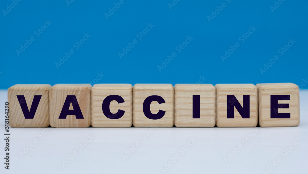 concept word vaccine on wooden cubes on a blue background concept word vaccine on wooden cubes on a blue background