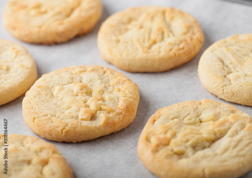 White chocolate biscuit cookies on baking tray on light kitchen table background. White chocolate biscuit cookies on baking tray on light kitchen table background.