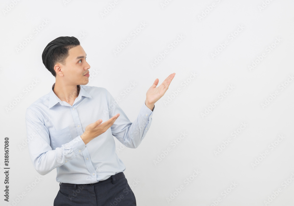 Young asian business man with blue shirt pointing to the side with a hand to present a product or an idea isolated on white background. Young asian business man with blue shirt pointing to the side with a hand to present a product or an idea isolated on white background.