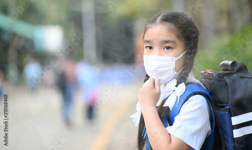 Little asian girl wearing a protective mask in school.Portrait Asian children girl wear mask to protect PM 2.5 dust and air pollution. 