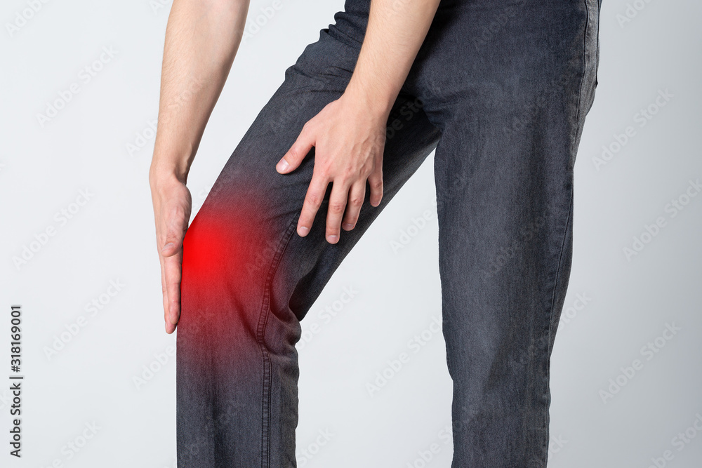 Knee pain, man with legs ache, studio shot on gray background