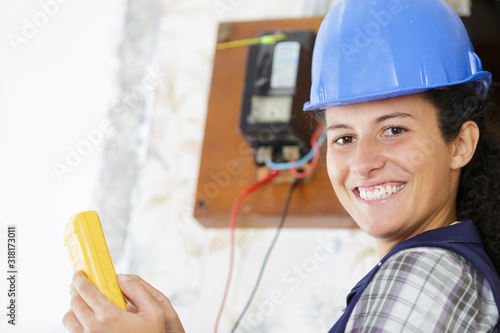 happy young female woker measuring electrical current photo