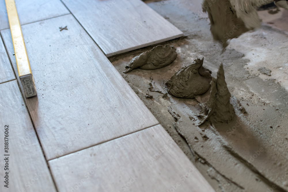 Obraz premium Close up shot of unfinished floor tiles installation in kitchen
