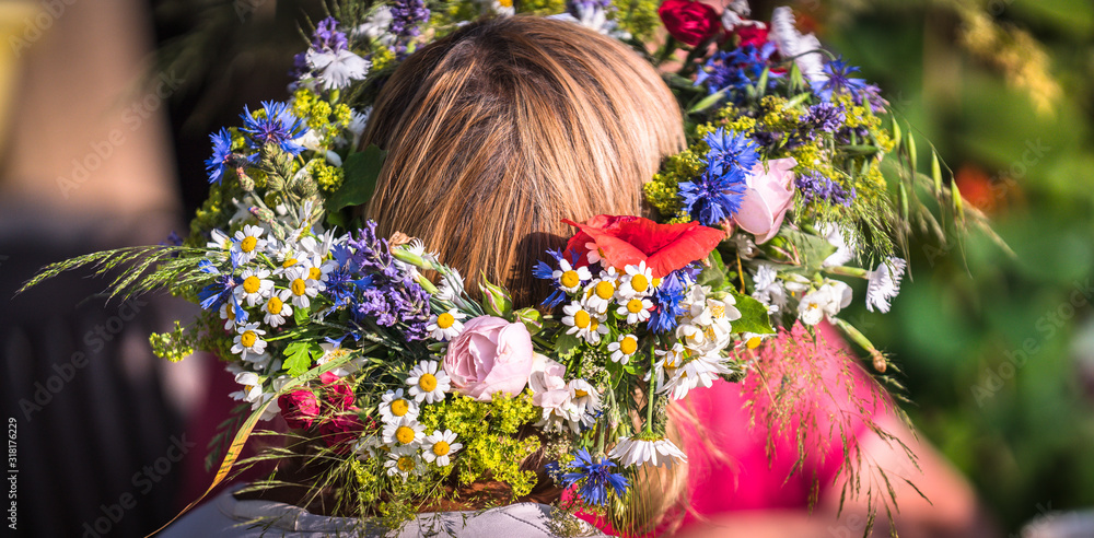 Naklejka premium summer solstice wreath on head, handmade, individual parts in focus, summer day